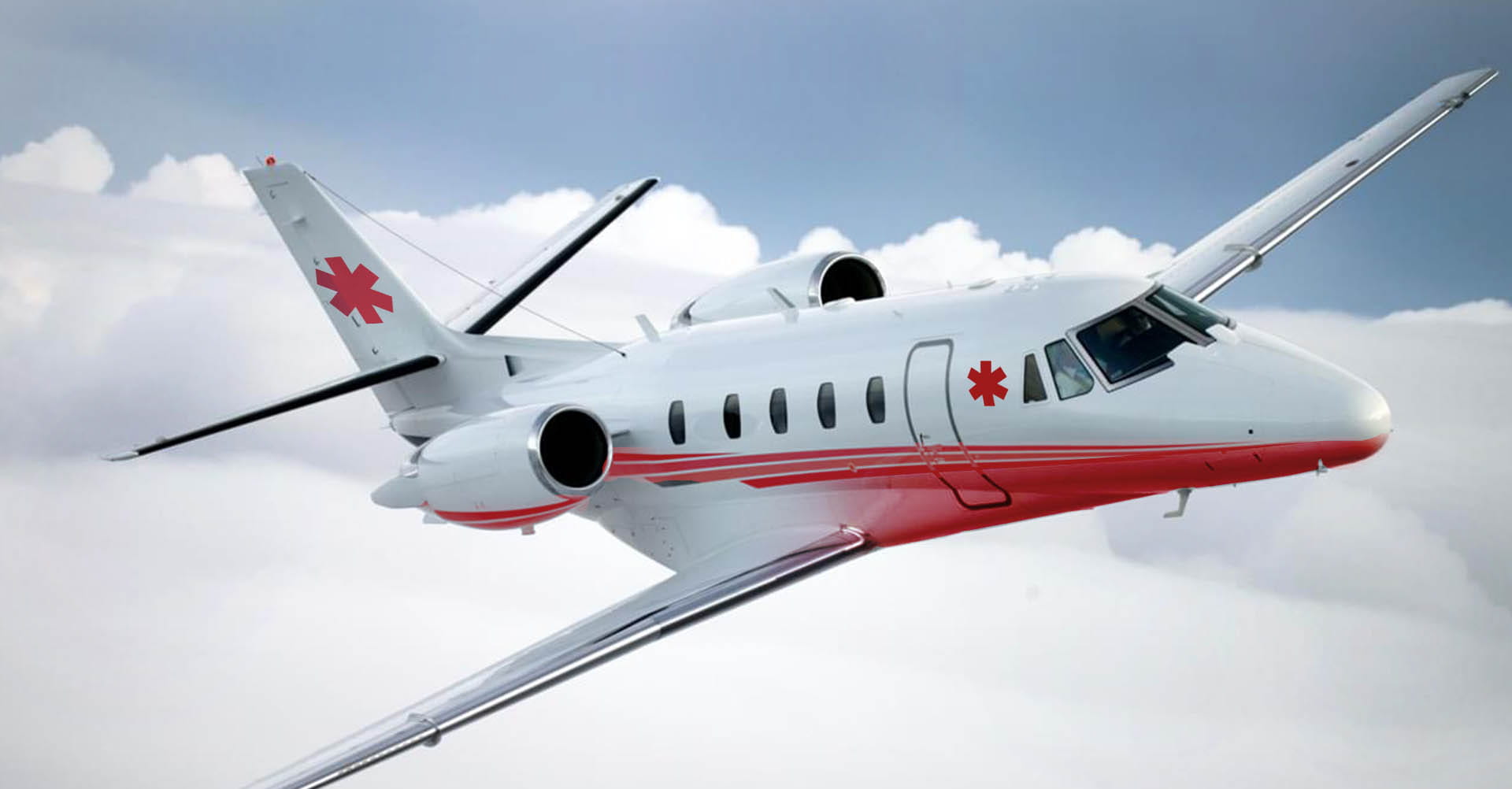 Jet sanitario Citation con cruces rojas en vuelo entre nubes